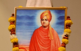 Student paying floral tributes to the portrait of Swami Vivekanand.